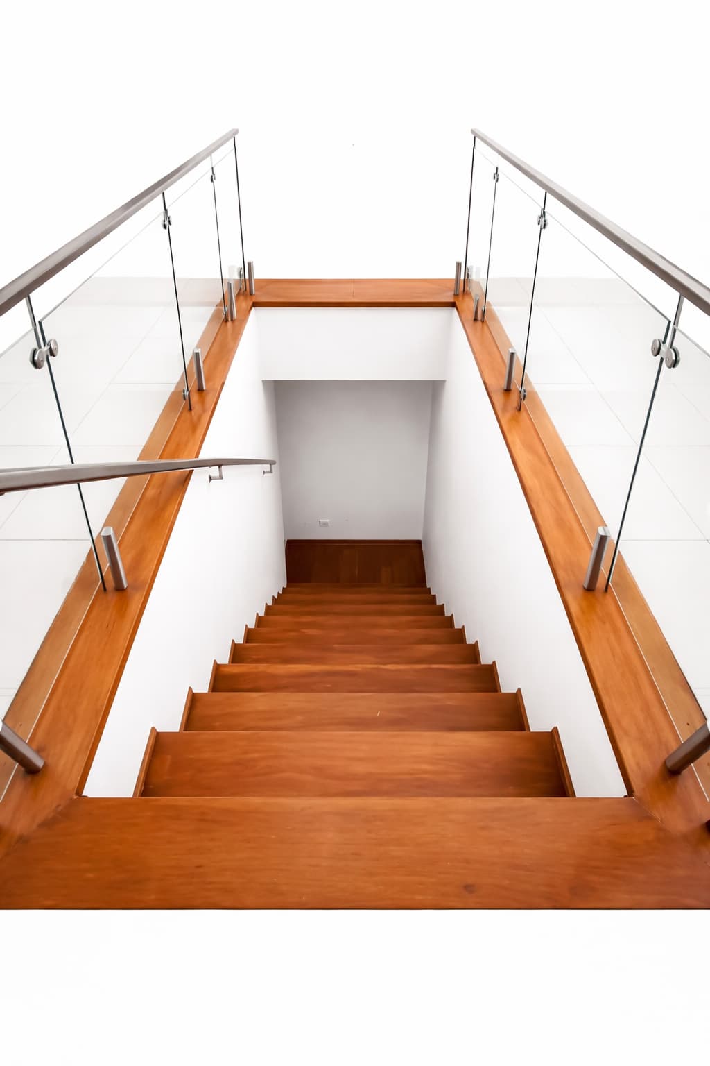 Escalera moderna de madera con barandas de cristal